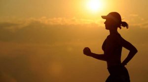 Silhouette of a person jogging during sunrise or sunset.