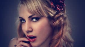 Close-up portrait of a woman with intense eyes and red lipstick.