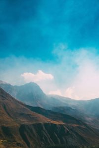 Mountain landscape with a bright blue sky and clouds.