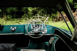 Rusty steering wheel and dashboard of an old abandoned car.