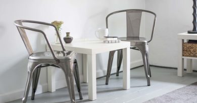 Minimalist white dining table with metal chairs in a bright room.