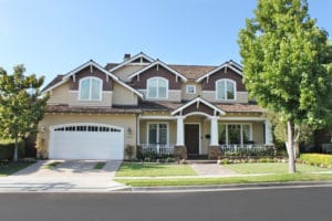 A large suburban house with a manicured lawn and driveway.
