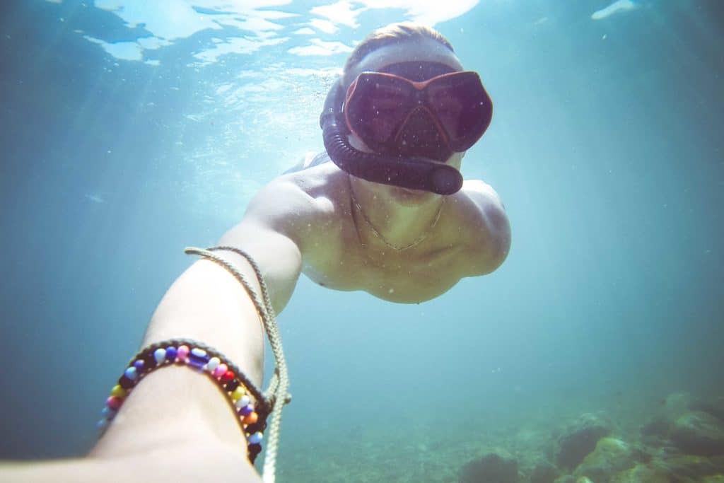 Underwater selfie of a person wearing a snorkeling mask.