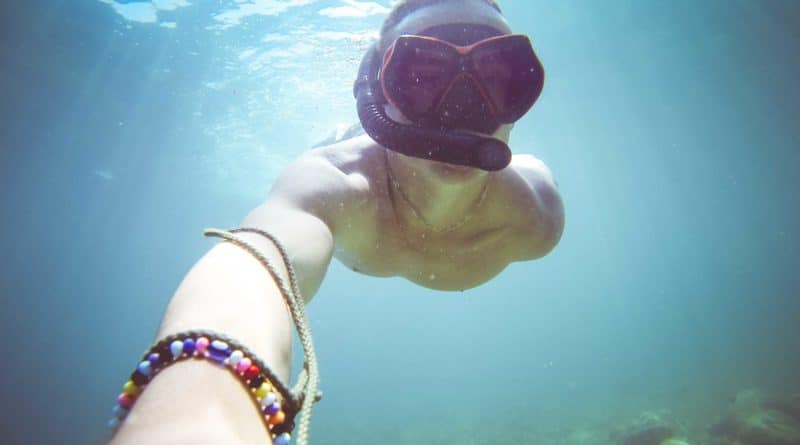 Underwater selfie of a person wearing a snorkeling mask.