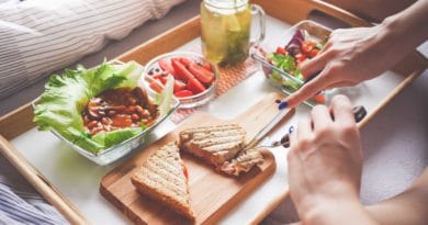 People enjoying a meal with grilled sandwiches and drinks at a cozy table.