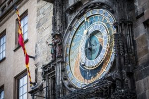 Close-up of an ornate historic astronomical clock on a stone building.