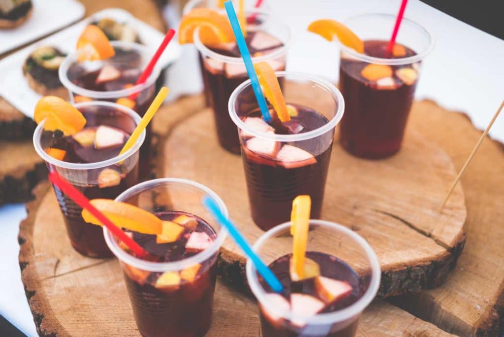 Cold drinks with ice and colorful straws in clear cups.