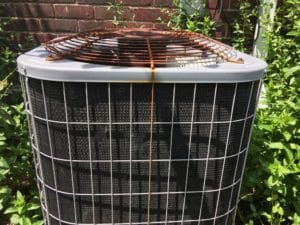 Rusty air conditioning unit with visible corrosion on top grille.