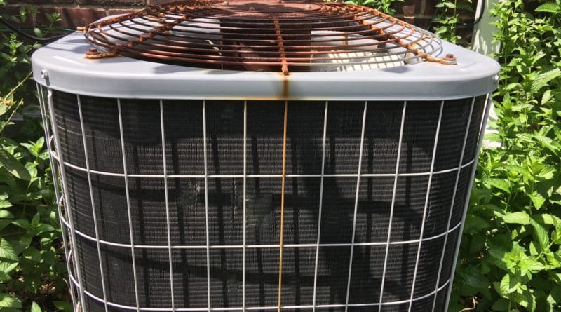 Rusty air conditioning unit with visible corrosion on top grille.