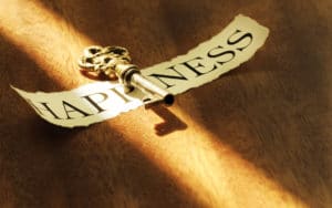 A vintage key casting a shadow over the word 'Happiness'.