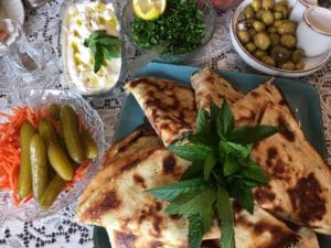 A spread of Middle Eastern dishes with flatbread and fresh herbs.