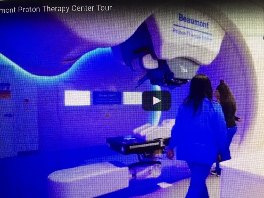 A person walks through a room illuminated with calming blue light and a therapy device.