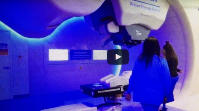 A person walks through a room illuminated with calming blue light and a therapy device.