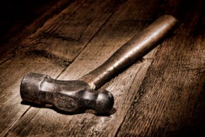 Close-up of a vintage hammer on a wooden surface.