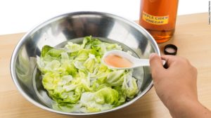 Fresh iceberg lettuce with creamy dressing in a metal bowl.
