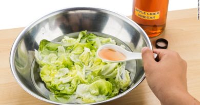 Fresh iceberg lettuce with creamy dressing in a metal bowl.