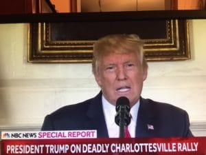 Donald Trump speaking at a podium during a news report.