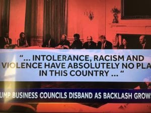 Protesters hold a large banner against intolerance and racism, condemning violence in the country.