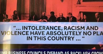 Protesters hold a large banner against intolerance and racism, condemning violence in the country.