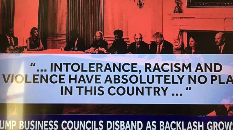 Protesters hold a large banner against intolerance and racism, condemning violence in the country.