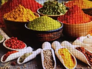 Colorful spices displayed in bowls and spoons.
