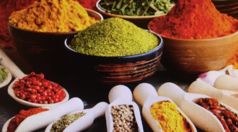 Colorful spices displayed in bowls and spoons.