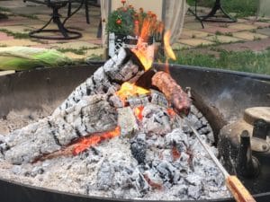 Glowing embers and burning logs in a fire pit.