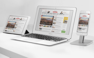 A laptop displaying a news website with a modern, clean design.