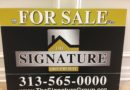Real estate sign for The Signature Group with contact information.