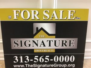 Real estate sign for The Signature Group with contact information.