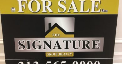 Real estate sign for The Signature Group with contact information.
