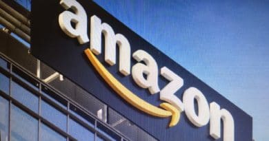 Amazon logo on a building exterior against a blue sky.