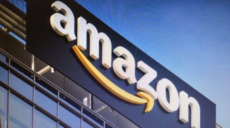 Amazon logo on a building exterior against a blue sky.