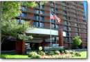 Entrance of a brick apartment complex with an American flag.