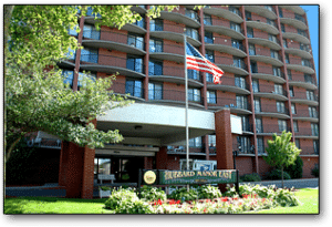 Entrance of a brick apartment complex with an American flag.