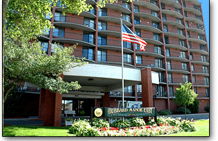 Entrance of a brick apartment complex with an American flag.