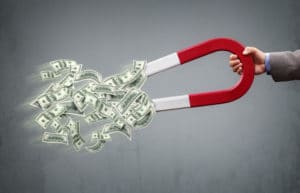 A horseshoe magnet attracting dollar bills.