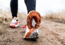 Close-up of a runner's shoe with mud on the sole during a trail run.
