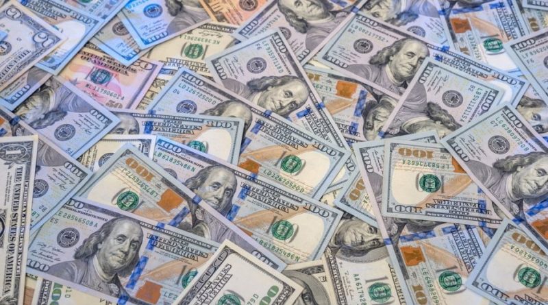 A pile of various US dollar bills spread out.