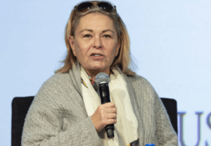 Woman speaking into a microphone during an event.