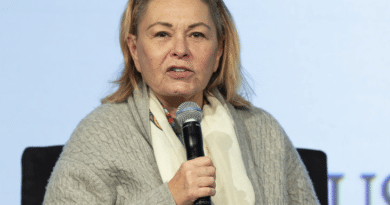 Woman speaking into a microphone during an event.