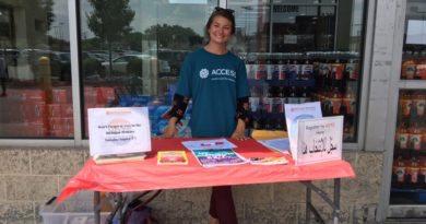 A woman stands behind a table promoting Touro University.