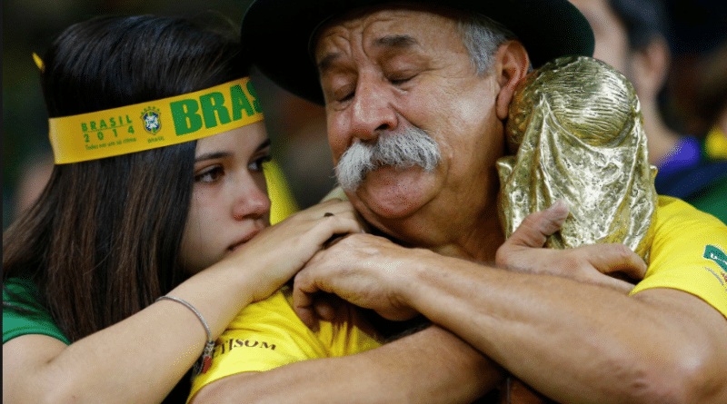 Emotional moment between two people in Brazil fan gear.