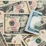 Various US dollar bills scattered on a surface.