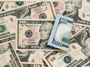 Various US dollar bills scattered on a surface.