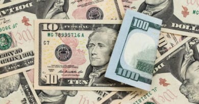 Various US dollar bills scattered on a surface.