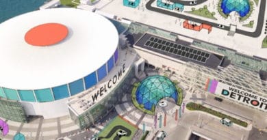 Aerial view of a large sports arena with surrounding parking and roads.