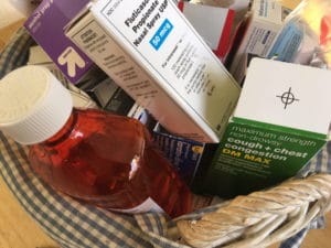 Basket filled with various medication bottles and boxes.