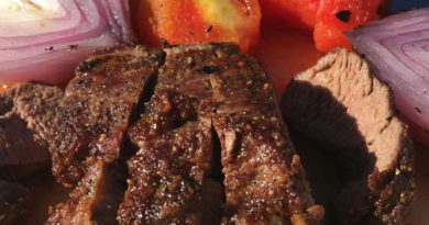 Close-up of a grilled steak with roasted vegetables.
