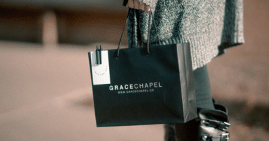 Person holding a Grace Chapel paper bag and a water bottle.
